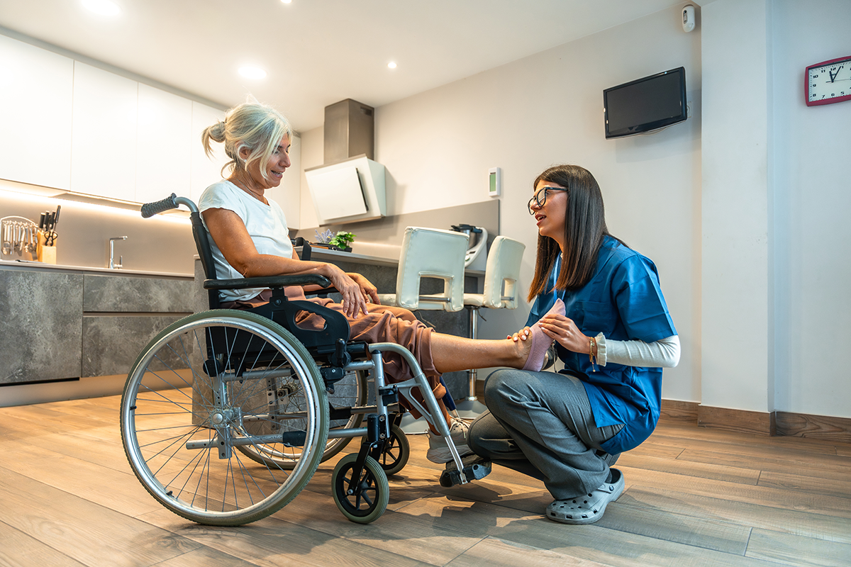 A woman in a wheelchair accessible clinic receiving a full foot evaluation from a certified, experienced foot expert for a stress free visit.